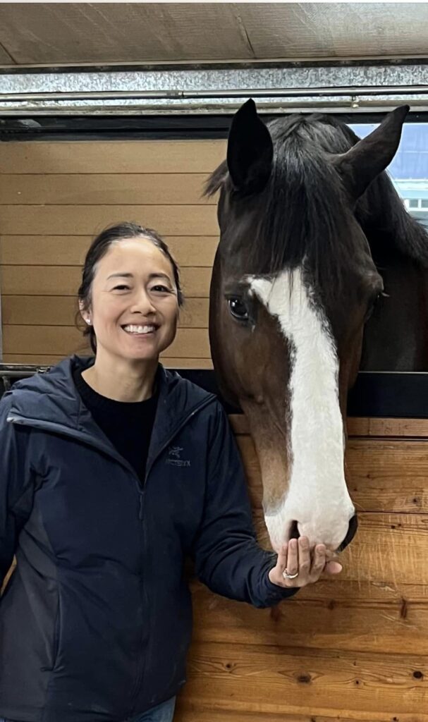 Person and horse in stable