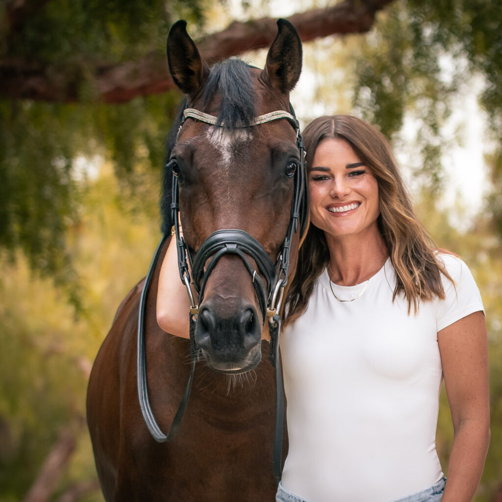 Christine smiling with a horse. 